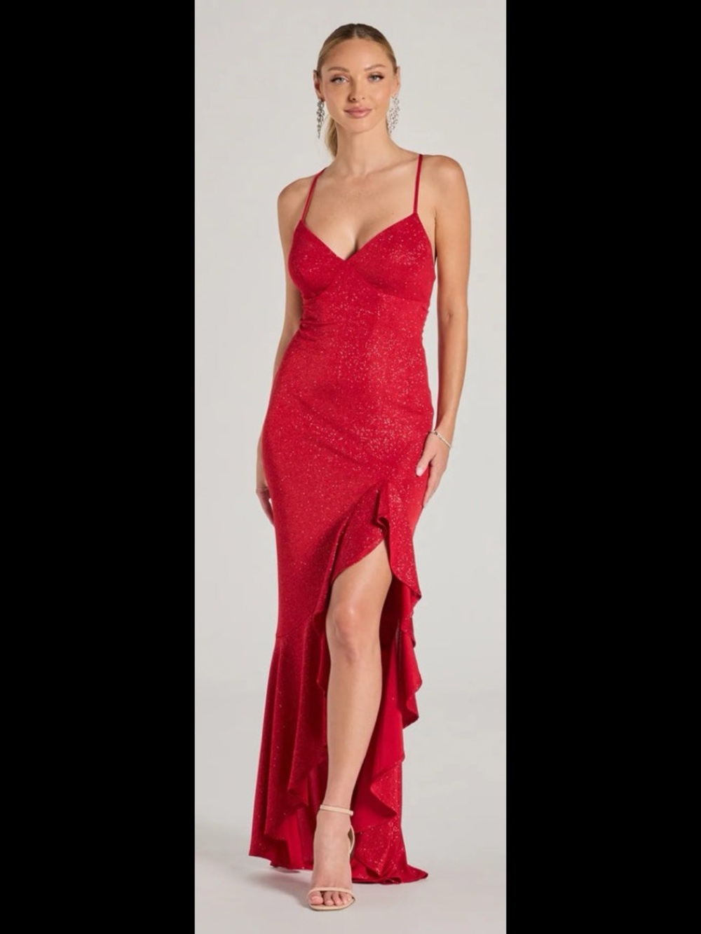 sleeveless glitter formal dress boasts a sultry V-neckline and spaghetti strap